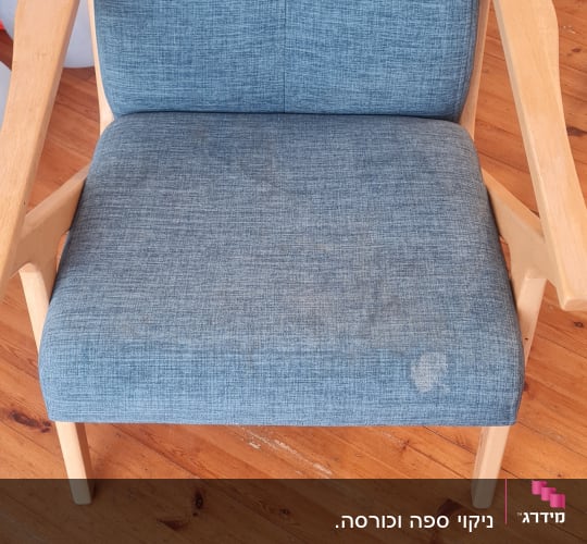 כיסא כחול עם כתמים על רצפת עץ